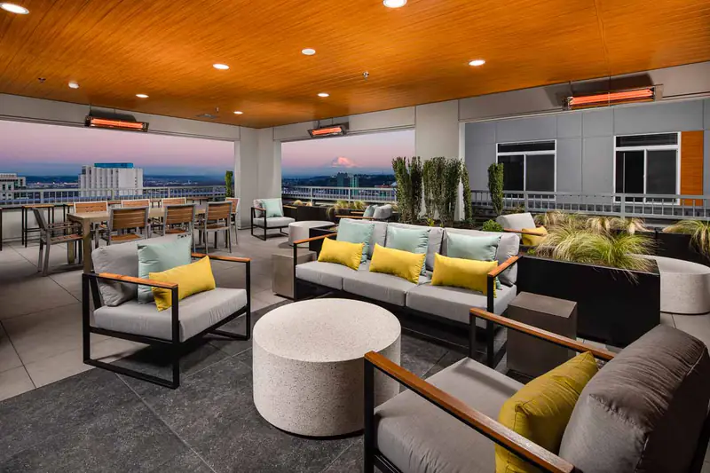 Apartments for Rent in Tacoma, WA - Hailey - Rooftop Lounge With Cushioned Seating, Dining Tables, Planters, Covered Ceiling, And Expansive City And Mountain Views.